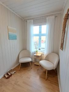 a room with two chairs and a window at Central and spacious 3-bedroom apartment in Mandal