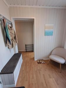 a room with a bed and a chair and a door at Central and spacious 3-bedroom apartment in Mandal