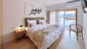 瓜尔达Verde Cantinho的一间卧室配有一张带椅子的床和一扇窗户