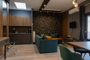 sala de estar con sillas verdes y mesa en Dioroh Suites Meteora 302, en Kalambaka