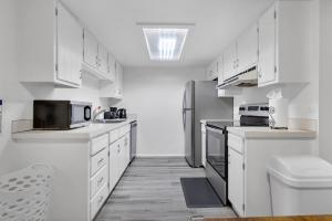 a kitchen with white cabinets and a stainless steel refrigerator at Central Bellevue Guesthouse in Bellevue +47 photos