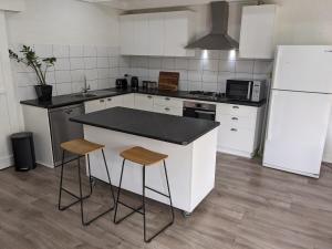 a kitchen with a white refrigerator and two bar stools at Heritage Chic in Central Albury in Albury