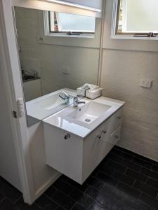 un bagno con un lavandino bianco e uno specchio di Heritage Chic in Central Albury ad Albury