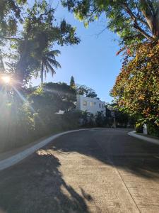 an empty road with trees and a house in the distance at JnF Suites Tagaytay in Tagaytay +20 photos