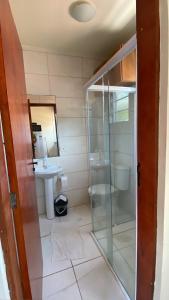 a bathroom with a glass shower and a sink at Apto 22 on the beach of maresias in São Sebastião