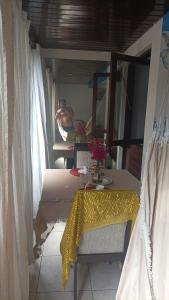a man in a bath tub in a room with a table at Flat Pé na areia in Natal