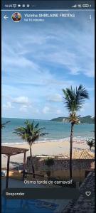 a picture of a beach with two palm trees at Flat Pé na areia in Natal