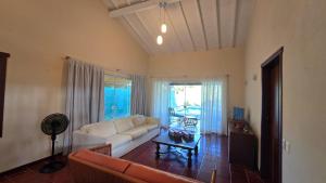 een woonkamer met een witte bank en een tafel bij Casa Colonial Cabore in Paraty