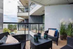 ein Balkon mit Stühlen und einem Tisch auf einem Gebäude in der Unterkunft Apartament Art w hotelu Seaside in Kołobrzeg