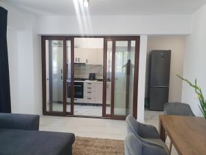 a living room with a large glass door leading to a kitchen at Kyr house 2 in Piteşti +10 photos