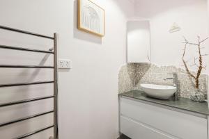 a bathroom with a sink and a mirror at Osprey 9 in Queenscliff +8 photos