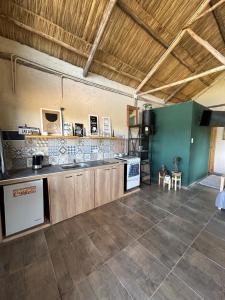 a large kitchen with wooden cabinets and a green wall at Cabanas Embau in San Rafael