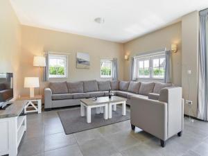 a living room with a couch and a table at Resort Villa Steps to Sand in Nieuwvliet