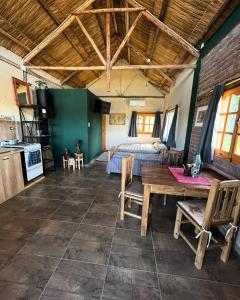 a bedroom with a bed and a table in a room at Cabanas Embau in San Rafael