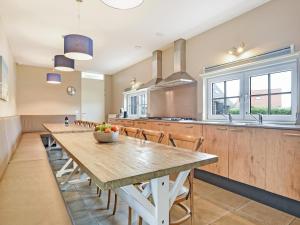 a large kitchen with a large wooden table and chairs at Resort Villa Steps to Sand in Nieuwvliet