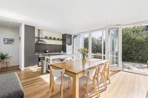 a kitchen and dining room with a wooden table and chairs at Perfect Family Getaway in Point Lonsdale