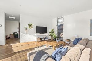 a living room with a couch and a tv at Perfect Family Getaway in Point Lonsdale