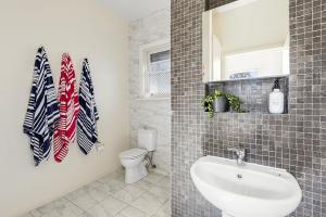 a bathroom with a sink and a toilet and a mirror at Perfect Family Getaway in Point Lonsdale +6 photos