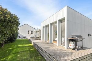 a barbecue on a wooden deck next to a house at Perfect Family Getaway in Point Lonsdale