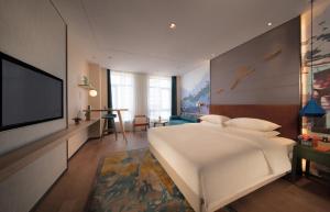 Un televizor și/sau centru de divertisment la Manju Hotel Zhuzhou Tianyuan District Midea City Times Square