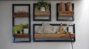 a wall with four wooden shelves on a wall at Casa Cayito Agua Dulce in Arecibo