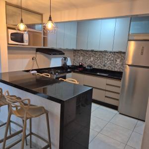 a kitchen with a stainless steel refrigerator and cabinets at Apartamento em Recife in Recife