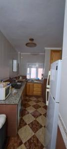 eine Küche mit einem weißen Kühlschrank und Fliesenboden in der Unterkunft Blue Wave Apartment in Temara