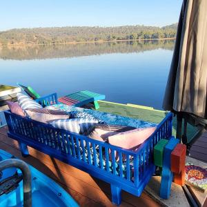 a blue crib sitting on the side of a body of water at Barefoot Bungalow 23 Lake Bennett -private pontoon in Lake Bennett