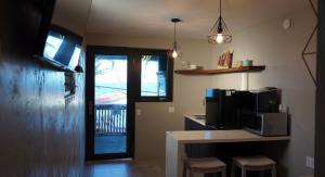 a kitchen with a microwave and a counter with stools at Casa Cayito ll in Arecibo