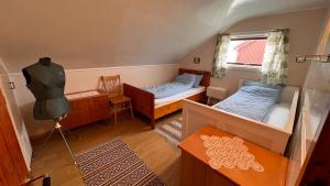 a small room with two beds and a window at Prestholmen Værøy Lofoten in Værøy