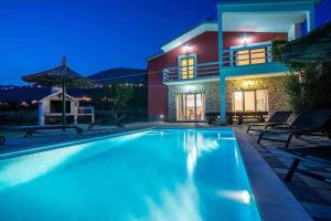 a villa with a swimming pool at night at Family friendly house with a swimming pool Srinjine, Split - 23950 in Srinjine
