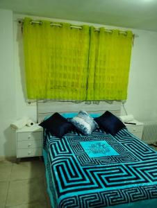 1 dormitorio con 1 cama con cortina amarilla en Alojamiento Sheril Zaidín 1, en Granada