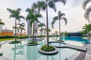 a pool with palm trees in a resort at Trion KL, Jalan Chan Sow Lin, Kuala Lumpur by One Guesthouse in Kuala Lumpur