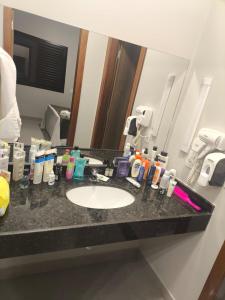 a bathroom counter with a sink and a mirror at Bangalô Grandes Lagos in Santa Clara dʼOeste