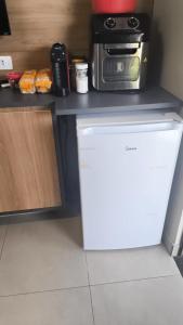 a kitchen with a microwave on top of a refrigerator at Bangalô Grandes Lagos in Santa Clara dʼOeste