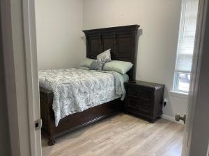 Un dormitorio con una cama con cabecero de madera. en Simple Modern House, en Oklahoma City