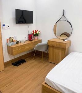 a bedroom with a mirror and a desk and a bed at Nhà nghỉ Hiền Anh gần Đại Lải in Trại Khao