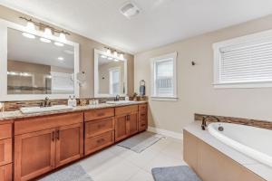 a bathroom with two sinks and a tub and a large mirror at Spacious family and kids friendly house with backyard, fireplace, grill perfect for work crews in Beaverton +14 photos