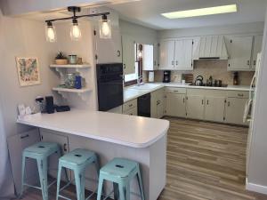 a kitchen with white cabinets and blue stools at My Roam'n Empire - Super Cute With Toys! in Empire
