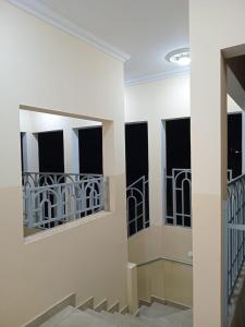 a hallway with two windows and a staircase at Appartements PALOU in Motsouémbé +2 photos