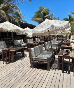 une terrasse avec des tables, des chaises et des parasols dans l'établissement Pôr do sol house, à Aracaju 42 autres photos
