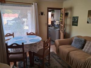 a living room with a table and a couch at Cabaña-RIO Calle Calle in Valdivia