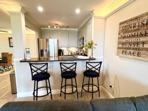 una cocina con una barra con tres taburetes en 2112 Landfall Way, en Seabrook Island