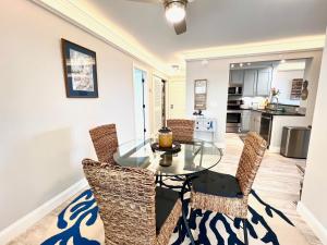 Un comedor con una mesa de cristal y sillas. en 2112 Landfall Way, en Seabrook Island