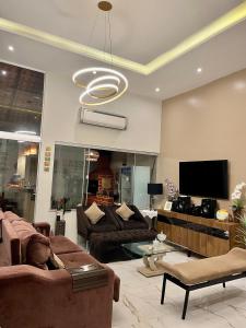 a living room with couches and a flat screen tv at Espetacular casa a 50m da praia in Salinópolis