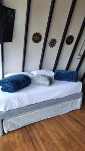a bed with two blue pillows on top of it at Glamping Arcoiris in Ciudad Bolívar