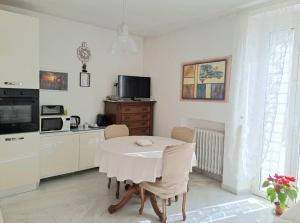 a white kitchen with a table and a microwave at DOMUS TEATE - Chieti in Chieti