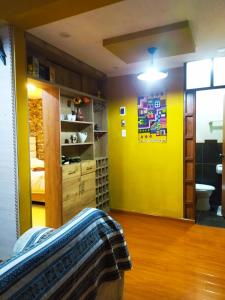 a room with a yellow wall and a bathroom at Alojamiento Místico in Ayacucho +6 photos