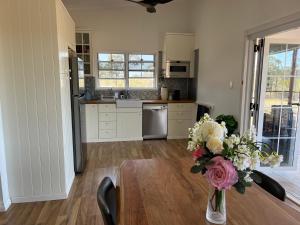 a kitchen with a table with a vase of flowers at Wallawa on Hilltop in Ellesmere