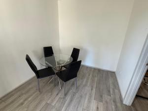 a glass table and four chairs in a room at 1 Bedroom House in Sunshine +2 photos